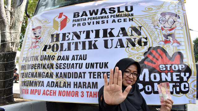 Seorang pengawas Pemilu 2019 memperagakan stop money politic saat apel siaga pengawasan di Banda Aceh, Jumat (12/4). Foto: Adi Warsidi/acehkini 