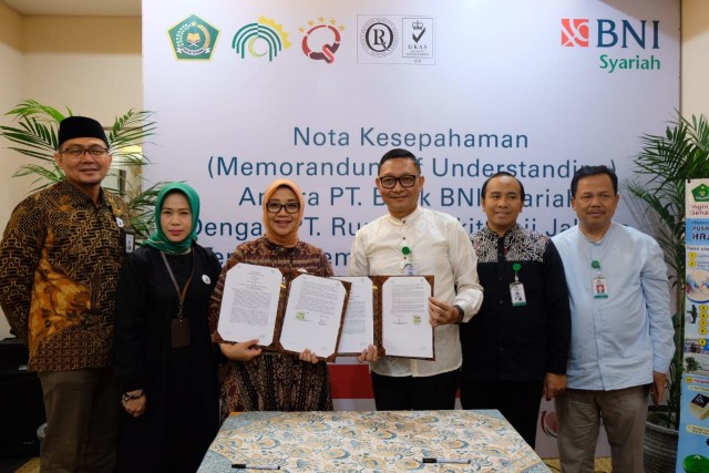 Penandatanganan nota kesepahaman (MoU) BNI Syariah dengan RS Haji Jakarta terkait pemanfaatan produk dan jasa perbankan syariah di ruang pusat pelayanan terpadu kesehatan haji dan umrah (P2TKHU) RS Haji Jakarta, Jumat (12/4) . Penandatanganan ini dilakukan oleh Direktur Bisnis Komersial BNI Syariah, Dhias Widhiyati dengan (ketiga dari kiri); dengan Direktur Utama RS Haji Jakarta Syarief Hasan Lutfie (kedua dari kanan). 