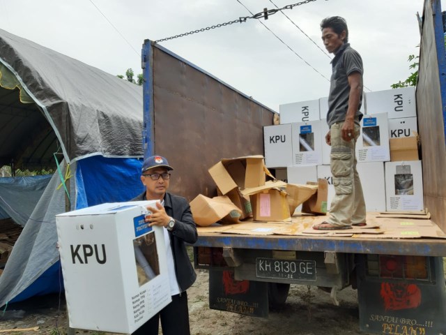 Ketua KPU Kobar Chaidir memindahkan kotak suara ke truk untuk di kirim ke Kecamatan Kotawaringin Lama. (Foto: Joko Hardyono)