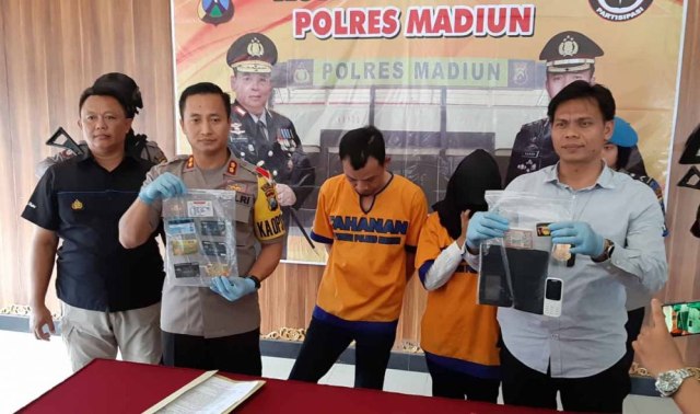 Kapolres Madiun, AKBP Ruruh Wicaksono menunjukkan barang bukti kejatahan dari suami istri penguras uang kartu ATM