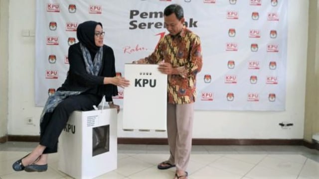 Komisioner KPU RI, Evi Novida Ginting Manik (kiri) dan Pramono Ubaid Tanthowi (kanan) menunjukan contoh kotak suara di Kantor KPU Pusat, di Jakarta, Jumat (14/12/2018).