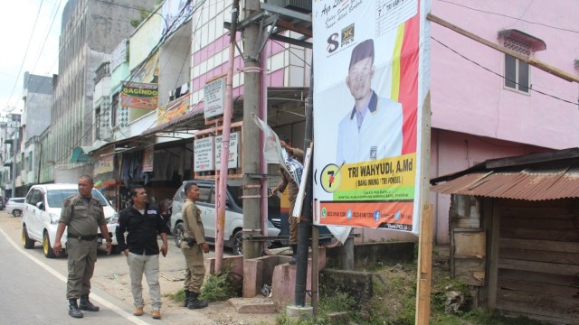 Satpol PP Kabupaten Aceh Tamiang membersihkan APK di hari tenang. Foto: Dok. Bawaslu Aceh Tamiang