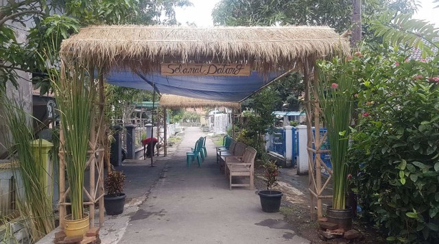 Tempat pemungutan suara (TPS) 54 di Desa Dadap,  Kecamatan Juntinyuat, Kabupaten Indramayu, Jawa Barat menggunakan terpal sebagai atap dan gapura yang terbuat dari bambu berhiaskan jerami. (Nafis)