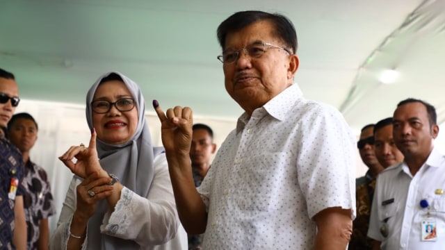 Wakil presiden Jusuf Kalla beserta istri menunjukan jari usai ikuti pemilihan umum di TPS. Foto: kevin kurnianto/kumparan
