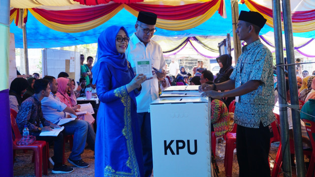 PLT Gubernur Aceh Nova Iriansyah (kedua dari kiri) saat menyalurkan hak suaranya di TPS  03 Desa Geuche Geuceu Kaye Jatho, Kecamatan Banda Raya, Banda Aceh. Foto: Zuhri Noviandi/kumparan
