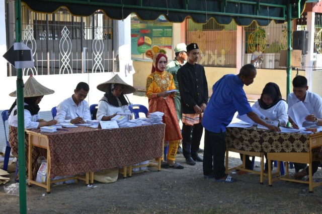 Suasana di TPS 2, ada yang berbaju adat dan ada yang berpakaian khas petani. Foto: Aceh Kini