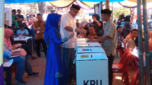 Plt Gubernur Aceh, Nova Iriansyah bersama istri memasukkan surat suara usai mencoblos. Foto: Habil/acehkini