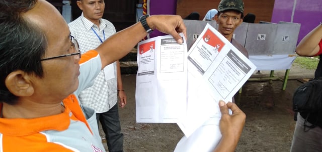 Petugas TPS 03 saat memeriksa surat suara yang telah tercoblos (istimewa)