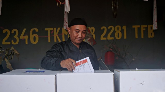 Seorang pemilih memasukkan kertas surat suara di tempat pemungutan suara (TPS) 73, Lebak Bulus, Jakarta, Rabu (17/4). Foto: Fanny Kusumawardhani/kumparan