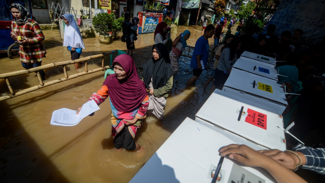 Warga memberikan hak suaranya di TPS 16 yang terdampak banjir di Bojongasih, Dayeuhkolot, Kabupaten Bandung, Jawa Barat, Rabu (17/4). Foto: ANTARA FOTO/Raisan Al Farisi