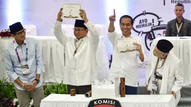 Paslon capres-cawapres nomor urut 01 dan 02, Jokowi-Ma'ruf dan Prabowo-Sandi menunjukkan nomor urut pengundian di KPU. Foto: AFP/Bay Ismoyo
