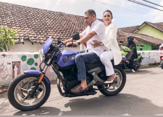 Krisdayanti naik motor usai nyoblos di TPS.