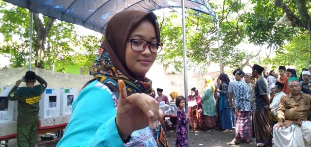 Warga Cirebon mencelupkan jari ke sari kunyit sebagai pengganti tinta pemilu.