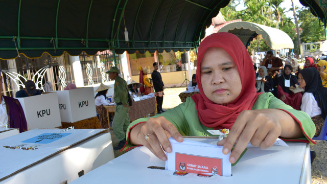 Seorang pemilih memasukkan suarat suara di TPS 2, Gampong Nusa, Kecamatan Lhoknga, Kabupaten Aceh Besar. Foto: Adi Warsidi/acehkini 