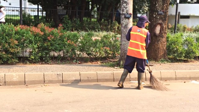 Petugas kebersihan GBK menyaou di pinggir jalan pada hari biasa. Foto: Iqbal Maulana/kumparan