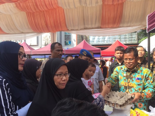 Wali Kota Banda Aceh melayani kaum ibu berbelanja di pasar murah, Sabtu (20/4). Foto: Humas Banda Aceh