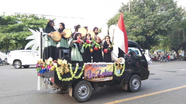 Para peserta festival hadroh memainkan kesenian hadroh sambil berkeliling menggunakan mobil di Sepanjang Jalan Slamet Riyadi hingga Balaikota, Sabtu (20/04/2019). (Tara Wahyu N.V.)
