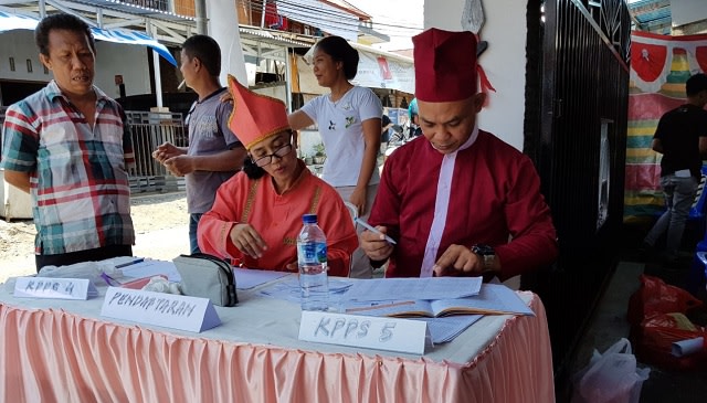 Petugas KPPS di Kota Manado menggunakan pakaian adat Nusa Utara saat bertugas pada Pemilu 2019
