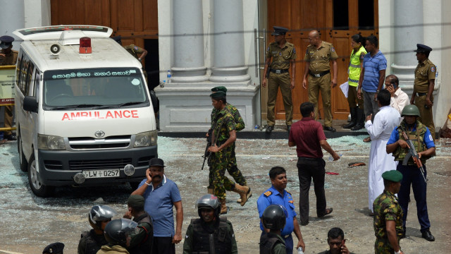 Sejumlah petugas keamanan dan mobil ambulans berada di sekitar ledakan gereja St. Anthony di Sri Lanka. Foto: AFP/ISHARA S. KODIKARA