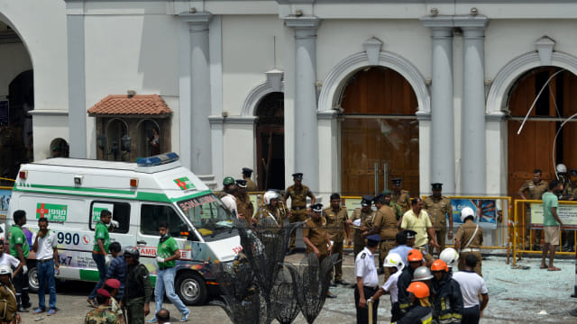 Sejumlah petugas keamanan dan mobil ambulans berada di sekitar ledakan gereja St. Anthony di Sri Lanka. Foto: AFP/ISHARA S. KODIKARA