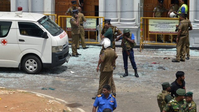 Sejumlah petugas keamanan dan mobil ambulans berada di sekitar ledakan gereja St. Anthony di Sri Lanka. Foto: AFP/ISHARA S. KODIKARA