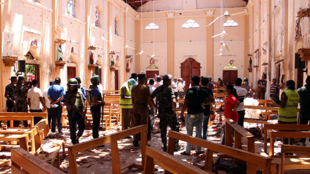 Sejumlah petugas keamanan dan warga sekitar berada di sekitar ledakan di Gereja St Sebastian di Negombo, utara ibukota Kolombo, Sri Lanka. Foto: AFP/STR