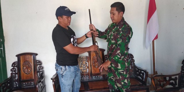Mulyono menyerahkan senjata api rakitan yang ia miliki kepada anggota TNI yang bertugas di perbatasan. Foto: Dok Hi!Pontianak 