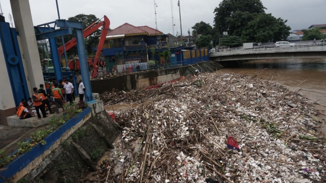 Sebuah alat berat membersihkan tumpukan sampah di Pintu Air Manggarai, Jakarta, Rabu, (24/4). Foto: Jamal Ramadhan/kumparan