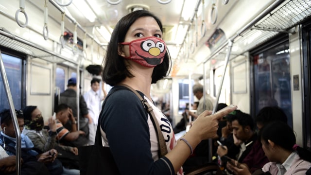 Ilustrasi Orang Pakai Masker. Foto: AFP/GOH CHAI HIN