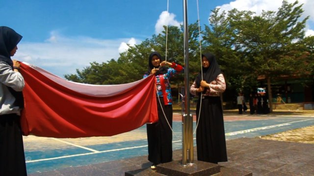 Marluna (tengah) dan teman-temannya melakukan penurunan bendera merah putih diperingatan hari Kartini I Foto : Dimas Prasetyo/Lampung Geh