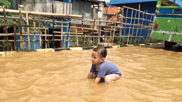 Anak-anak bermain di kawasan banjir di Bukit Duri, Kampung Melayu, Jakarta Timur. Foto: Darin Atiandina/kumparan