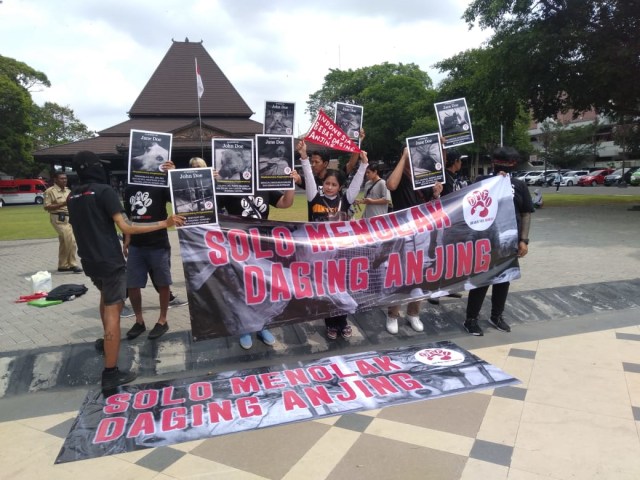 Beberapa aktivis Dog Met Free Indonesia (DMFI) saat melakukan aksi terkait penolakan perdagangan daging anjing pada Jumat (26/4/2019). (Tara Wahyu N.V.)