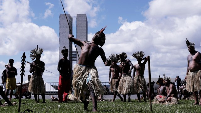 Warga dari suku di Brasil membawa panah dan tombak saat protes  di depan gedung pemerintahan. Foto: REUTERS/Nacho Doce