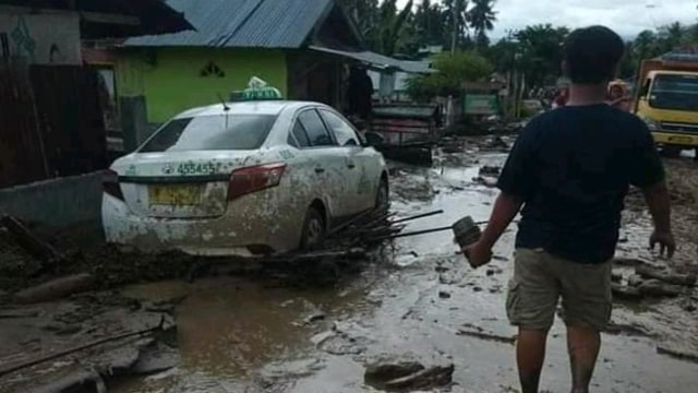 Sebuah mobil taksi usai dihantam banjir terparkir di jalur Poros Palu-Bangga di Desa Balongga, Kecamatan Dolo Selatan, Kabupaten Sigi. Foto: Istimewa