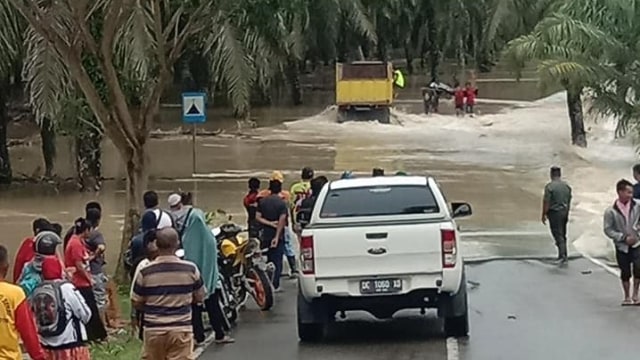 Banjir di Desa Lariang, Kecamatan Tikke, Kabupaten Pasangkayu, menyebabkan akses Jalan Trans Sulawesi terhambat. Foto: Istimewa