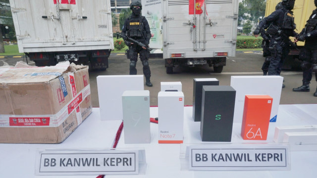 Sejumlah petugas berjaga di dekat barang bukti elektronik ilegal hasil penindakan di Direktorat Jenderal Bea dan Cukai, Jakarta, Selasa (30/4). Foto: Irfan Adi Saputra/kumparan