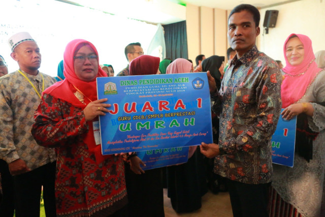 Kepala Dinas Pendidikan Aceh, Syaridin, menyerahkan hadiah umrah sebagai bentuk apresiasi dari Pemerintah Aceh kepada guru berprestasi tahun 2019. Foto: Dok. Disdik Aceh