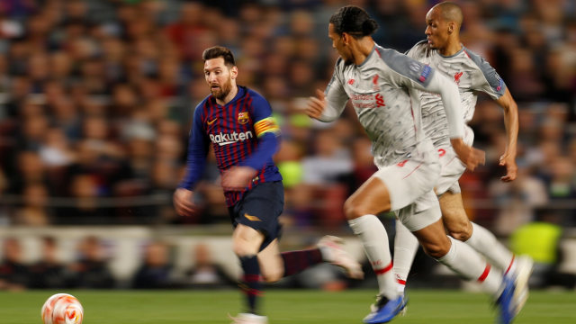 Lionel Messi diadang oleh Fabinho dan Virgil van Dijk. Foto: Reuters/John Sibley
