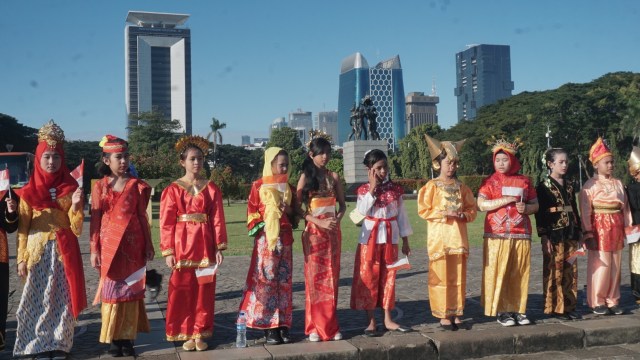 Sejumlah peserta Upacara Pengibaran Bendera Merah Putih dalam rangka Peringatan Hari Pendidikan Nasional Tahun 2019 mengeakan pakaian adat dari berbagai daerah di Monas. Foto: Irfan Adi Saputra/kumparan