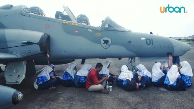 Sejumlah siswa memanfaatkan badan pesawat Hawk 109 untuk sekedar berteduh, Kamis (2/5) Foto: ABP/Urban Id