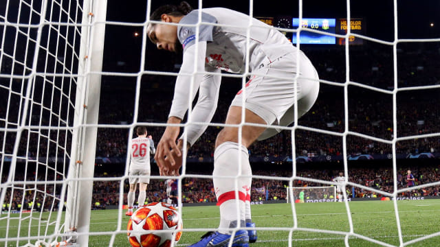 Virgil van Dijk memungut bola dari gawang dalam laga Barcelona vs Liverpool. Foto: Susana Vera/Reuters