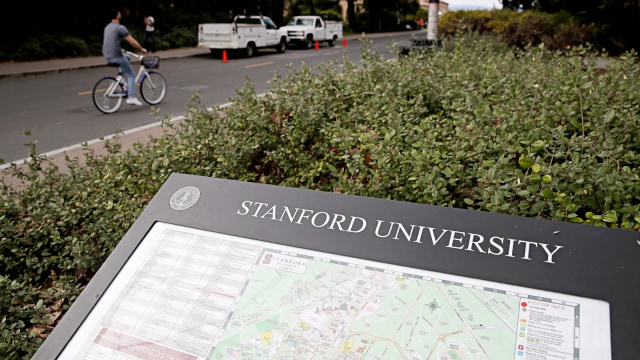 Seorang pria bersepeda melewati peta Universitas Stanford. Foto: Getty Images