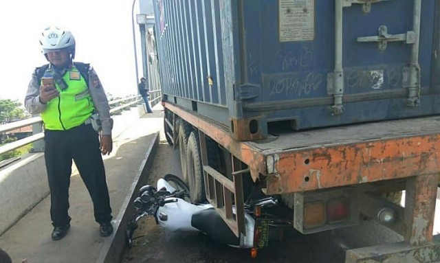 Ipda Tatang dan motor dinasnya yang menjadi ganjal untuk tronton yang mogok di atas Jembatan Kapuas 2, Kubu Raya. Foto: akun Instagram @pnc_poldakalbar