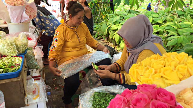 Lasti (melipat plastik) sedang merapikan bunga yang akan dijual. Foto: Darin Atiandina/kumparan