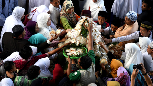 Warga bersiap-siap membagikan kue apem saat digelar 'Megengan Kubro' di Masjid Al Akbar Surabaya, Jawa Timur, Jumat (3/5/2019). Foto: ANTARA FOTO/Zabur Karuru