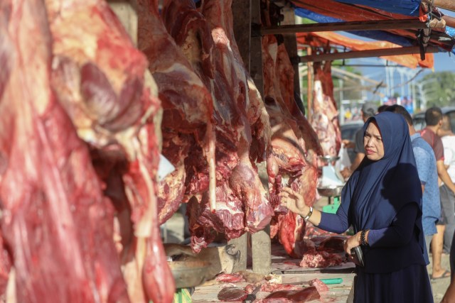 Seorang ibu rumah tangga di Banda Aceh memilih daging untuk dibelinya di hari meugang jelang Ramadan di pasar Beurawe, Sabtu (4/5). Foto: Suparta/acehkini