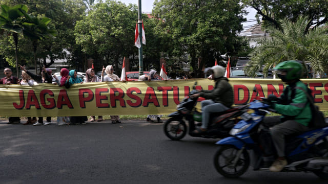 Sejumlah massa mebentangkan spanduk berisi ujaran damai sepanjang 1km di depan Gedung KPU RI, Jakarta, Sabtu (4/5). Aksi ini dilakukan oleh massa relawan dan emak-emak militan 02 yang menyuarakan mencintai kedamaian dan kejujuran. Foto: Fanny Kusumawardhani/kumparan