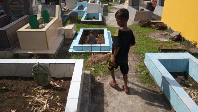 Jaki, salah satu bocah pembersih makam saat hendak membersihkan makam di Ternate, Maluku Utara. Foto: Rizal Syam/cermat