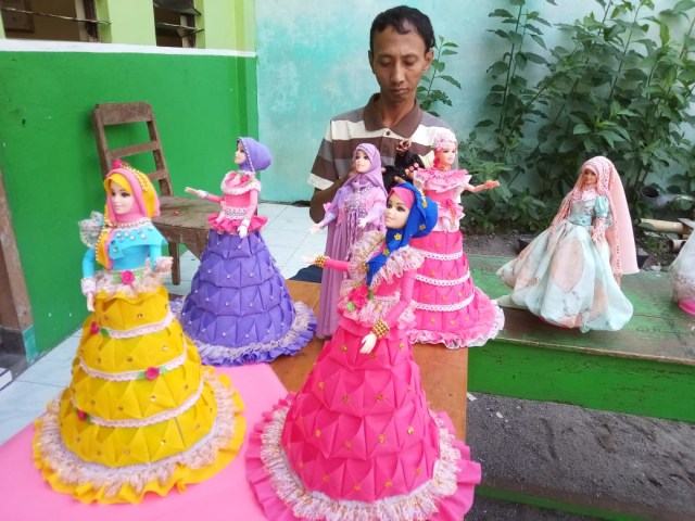 Ruby Yanto (39) menunjukkan beberapa conton boneka Barbie dengan kostum muslimah produksinya. (Agung Santoso)