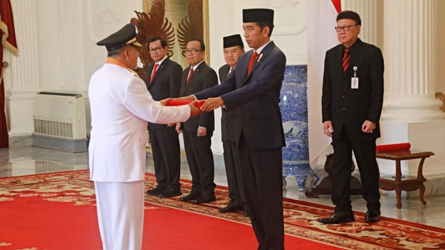Presiden Jokowi menyerahkan secara simbolis bendera merah putih kepada Gubernur Maluku Utara Abdul Gani dan Wakil Gubernur Maluku Utara Al Yasin saat pelantikan. Foto: Dok. Kemendagri